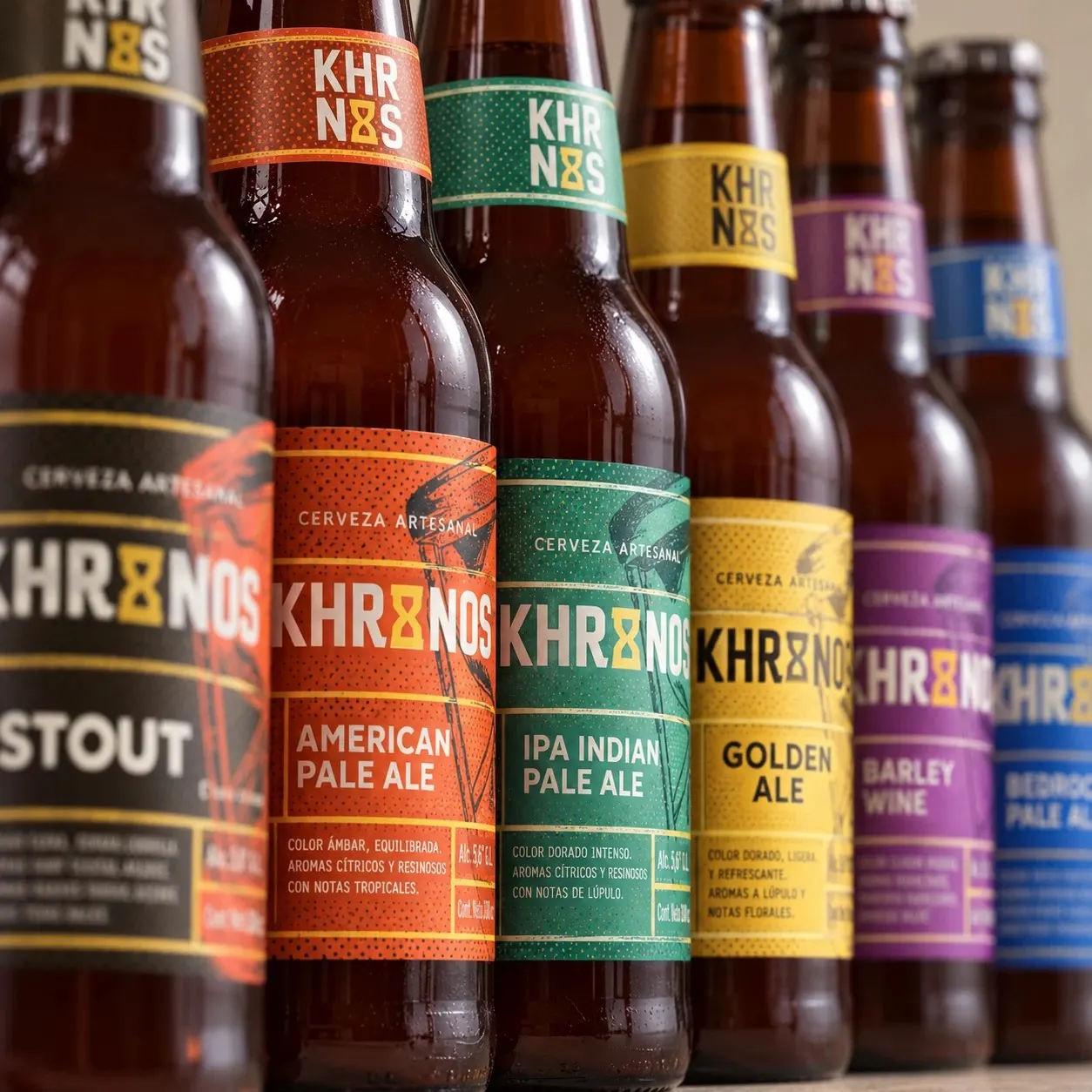 Fila de botellas Khronos con etiquetas de colores para cada variedad.